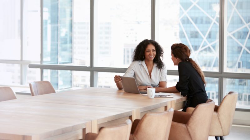 Two Woman Talking at Conference Table