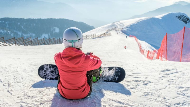 Female Snowboarder Staring Down a Ski Hill