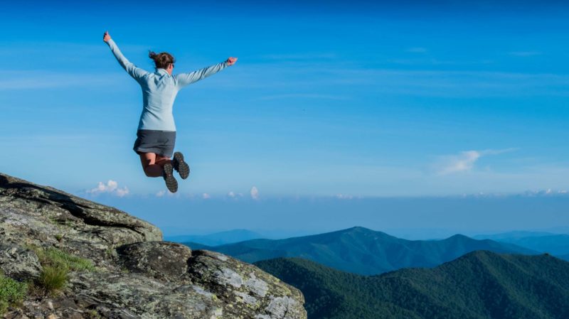 Woman Leaping in the Air on a Mountaintop