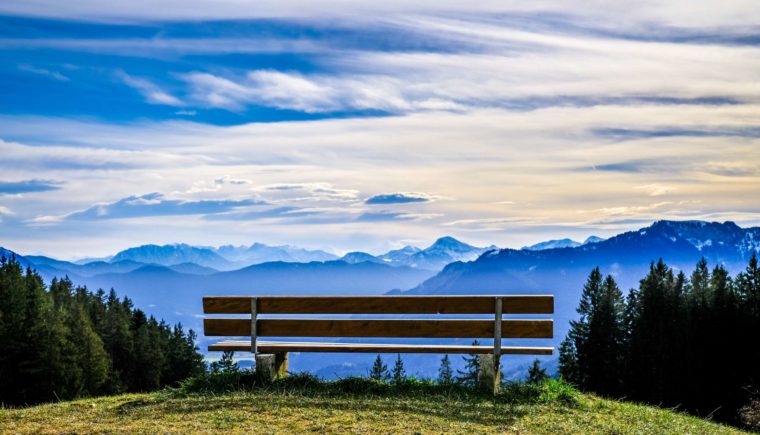 Empty park bench overlooking a mountaintop