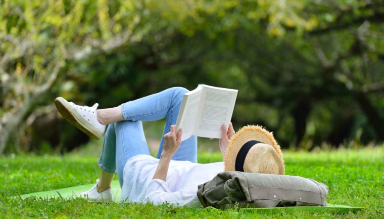 Woman Reading a Book on the Grass