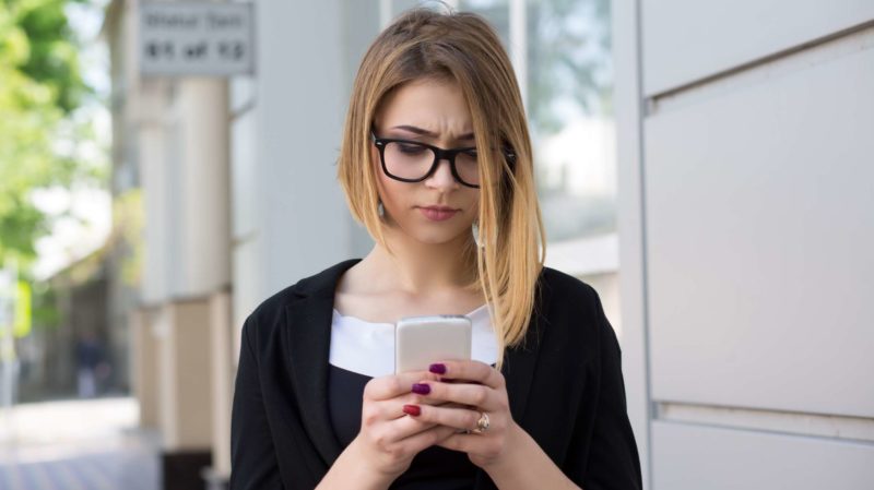 Concerned Woman Looking at Her Phone