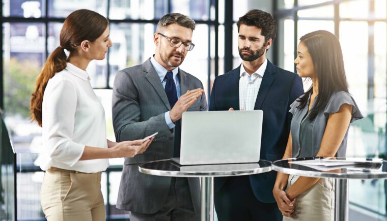 Team having a discussion around a laptop