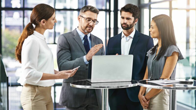 Team having a discussion around a laptop