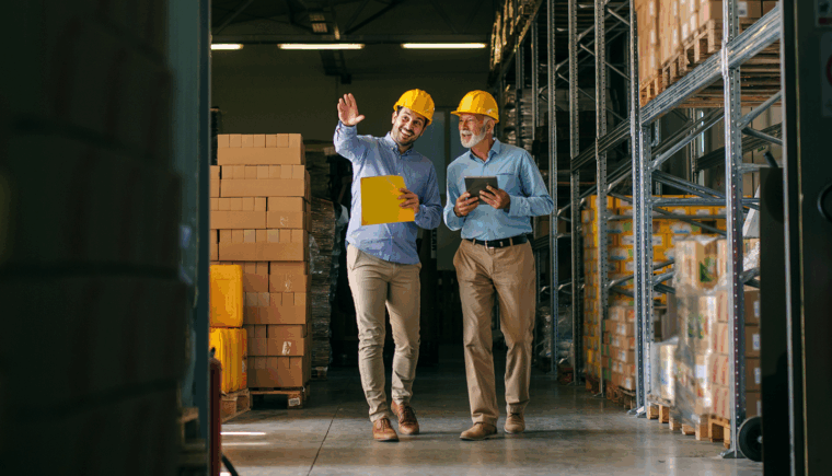 Two warehouse workers walking side by side.