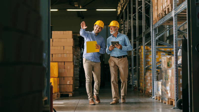 Two warehouse workers walking side by side.