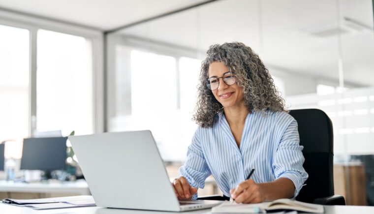 Woman at her laptop taking notes
