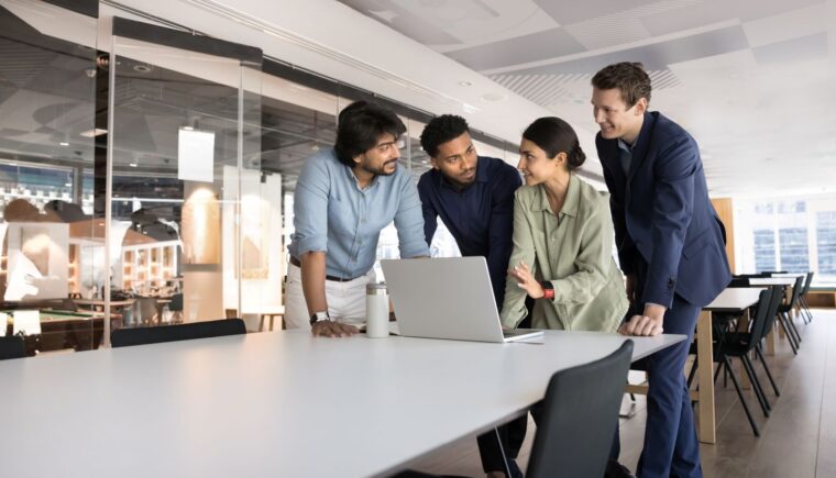 Team reviewing work on a laptop