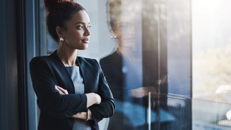 Businesswoman reflecting and looking out the window