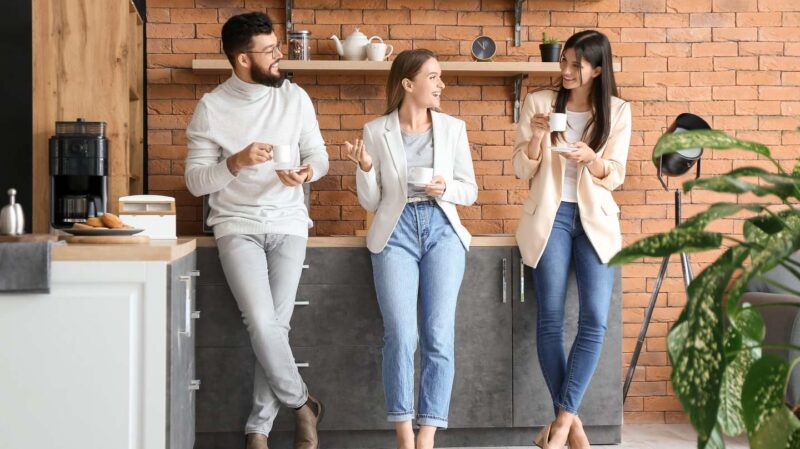 Colleagues talking while drinking coffee
