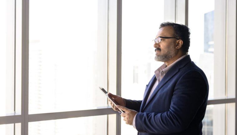 Man looking out the window at an office