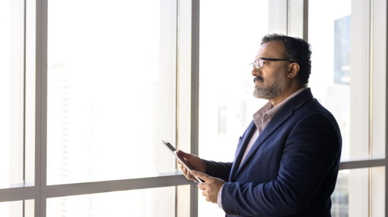 Man looking out the window at an office